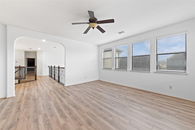 17803 Paint Bluff Ln, Cypress, TX 77433 - unfurnished room featuring arched walkways, light wood-style floors, ceiling fan, and baseboards