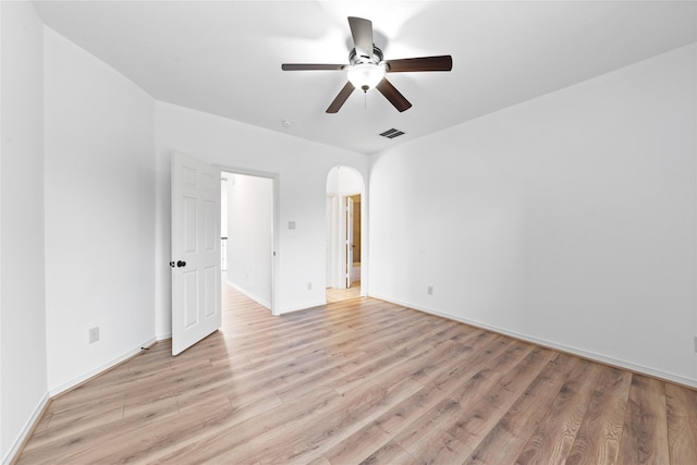 17803 Paint Bluff Ln, Cypress, TX 77433 - empty room with a ceiling fan, light wood-style floors, arched walkways, and baseboards