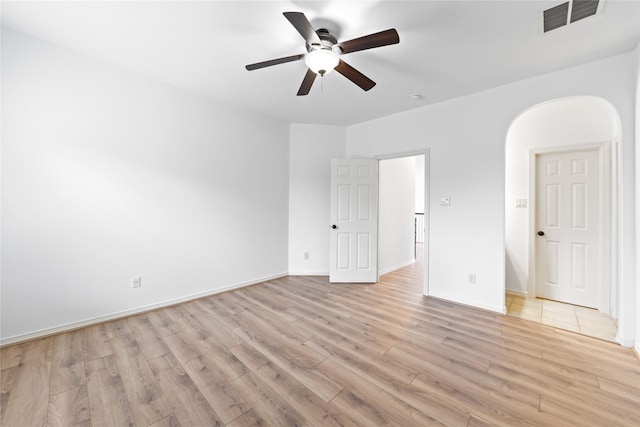 17803 Paint Bluff Ln, Cypress, TX 77433 - spare room with light wood-style floors, a ceiling fan, arched walkways, and baseboards