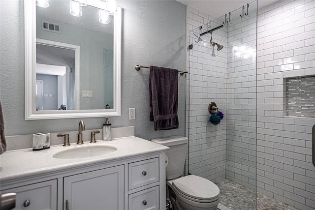 301 Commander Dr, Tiki Island, TX 77554 - full bath with a tile shower, a textured wall, vanity, and toilet