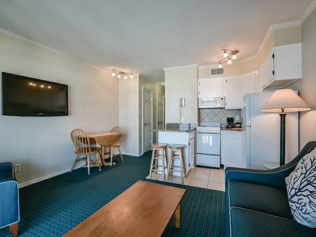 6102 Seawall Blvd Unit 261, Galveston, TX 77551 - living area featuring crown molding, rail lighting, a textured ceiling, baseboards, and light colored carpet