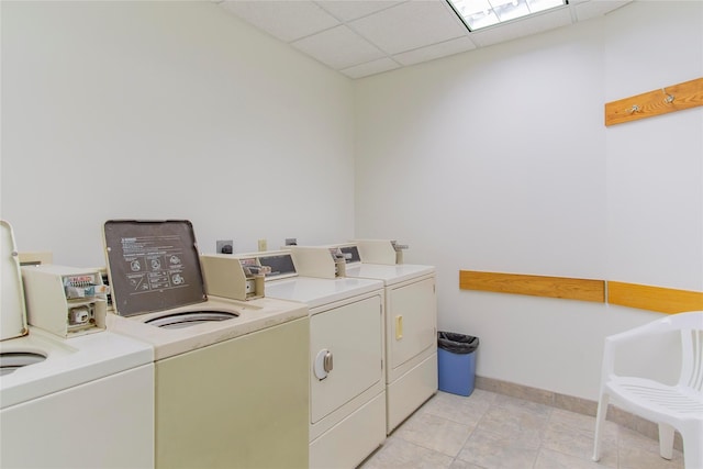 6102 Seawall Blvd Unit 261, Galveston, TX 77551 - community laundry featuring washer and dryer, baseboards, and light tile patterned flooring