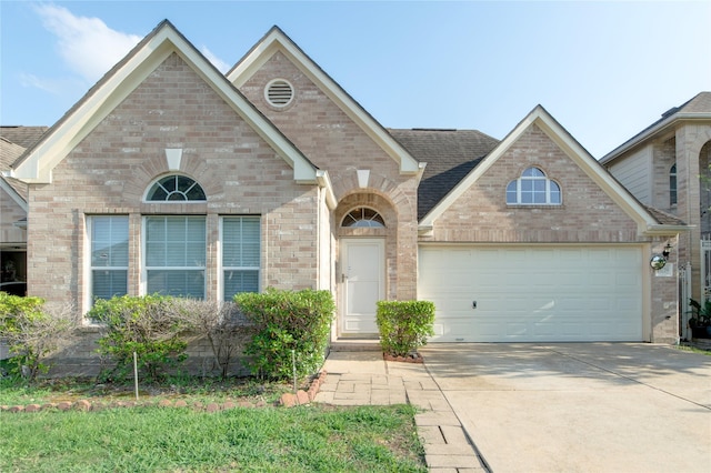 traditional home with brick siding, driveway, and a garage