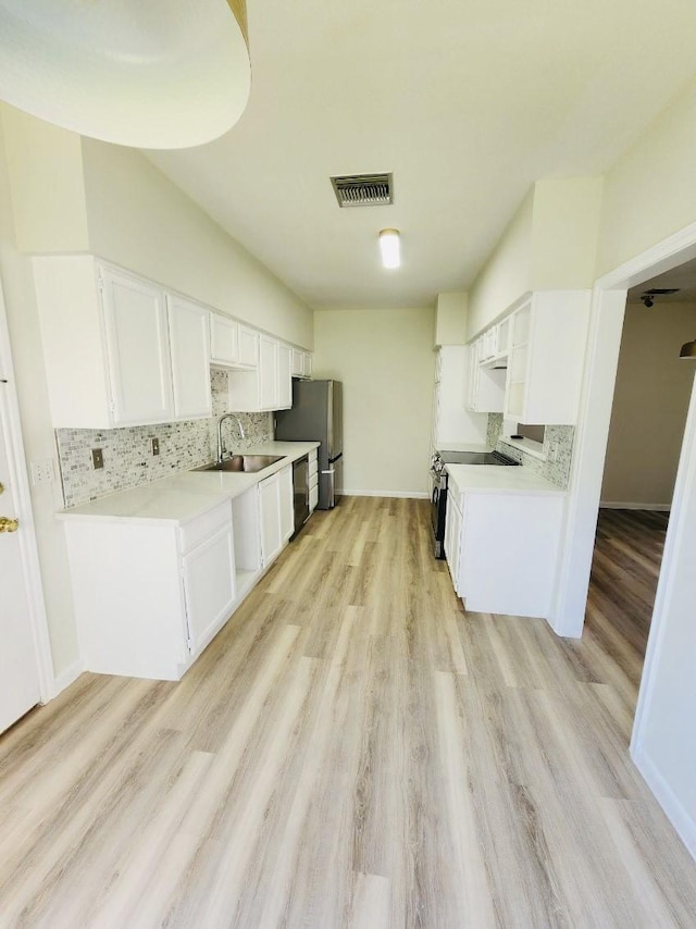 2668 Bering Dr Unit 2668, Houston, TX 77057 - kitchen featuring a sink, decorative backsplash, stainless steel appliances, and light wood finished floors
