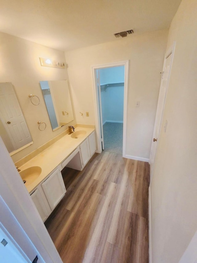 2668 Bering Dr Unit 2668, Houston, TX 77057 - bathroom featuring wood finished floors, double vanity, and a spacious closet