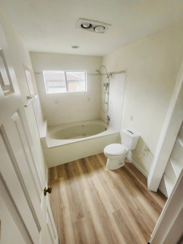 2668 Bering Dr Unit 2668, Houston, TX 77057 - bathroom with toilet, a combined bath / shower with jetted tub, and wood finished floors