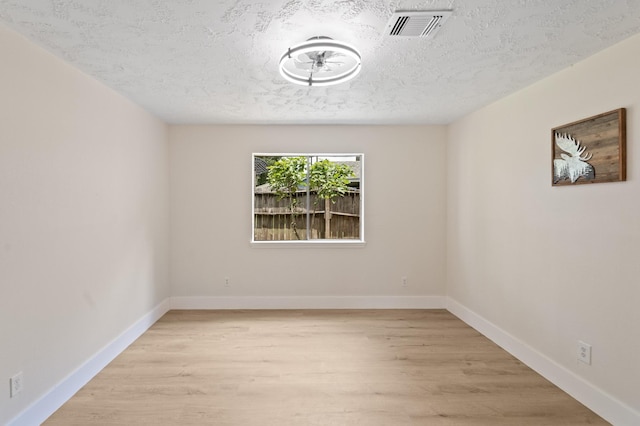 8619 Pearl Point St, Houston, TX 77044 - empty room featuring light wood-style flooring, a textured ceiling, and baseboards