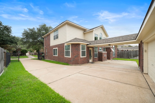 18231 Emerald Stone Ln, Houston, TX 77094 - view of side of home with brick siding, driveway, an attached carport, and a patio area