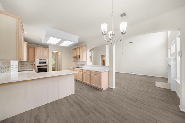 18231 Emerald Stone Ln, Houston, TX 77094 - kitchen with light brown cabinets, arched walkways, a sink, and wood finished floors