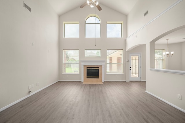 18231 Emerald Stone Ln, Houston, TX 77094 - unfurnished living room with ceiling fan, a chandelier, wood finished floors, a tiled fireplace, and plenty of natural light