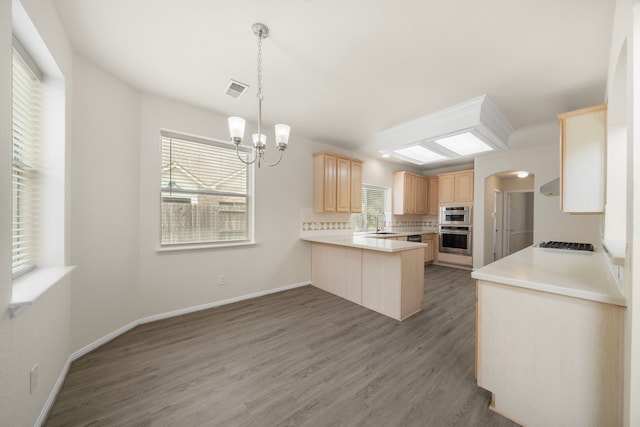 18231 Emerald Stone Ln, Houston, TX 77094 - kitchen featuring light brown cabinets, a sink, a peninsula, stovetop, and light wood finished floors