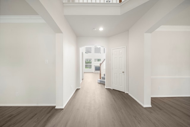 18231 Emerald Stone Ln, Houston, TX 77094 - corridor featuring wood finished floors, baseboards, arched walkways, crown molding, and stairway