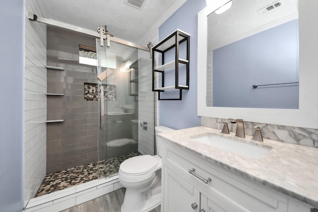 2323 Chalet Rd, Houston, TX 77038 - bathroom with a textured ceiling, toilet, a shower stall, vanity, and wood finished floors