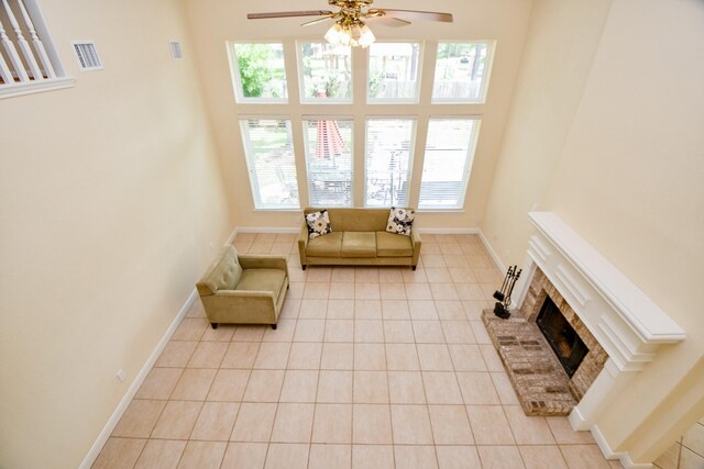 1307 Remington Crest Dr, Houston, TX 77094 - living area featuring light tile patterned flooring, ceiling fan, plenty of natural light, a brick fireplace, and a high ceiling