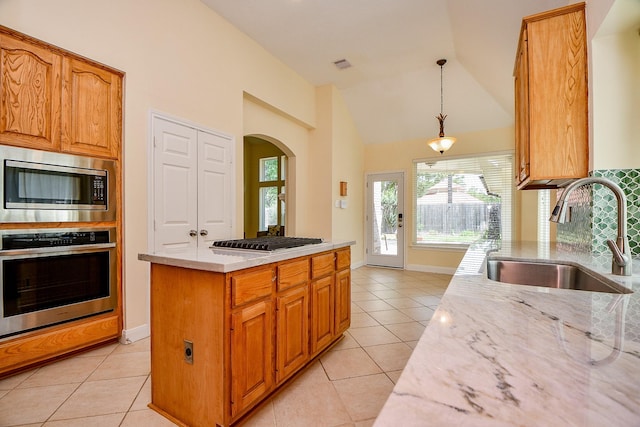 1307 Remington Crest Dr, Houston, TX 77094 - kitchen featuring stainless steel appliances, a sink, light tile patterned flooring, light stone counters, and vaulted ceiling