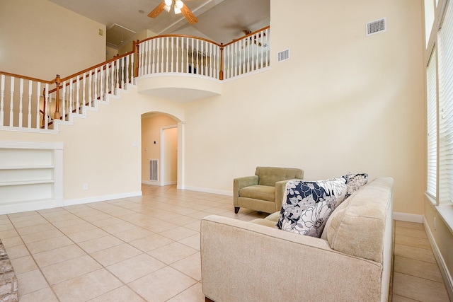 1307 Remington Crest Dr, Houston, TX 77094 - living room with built in features, tile patterned floors, a ceiling fan, a towering ceiling, and arched walkways