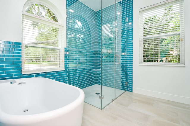 1307 Remington Crest Dr, Houston, TX 77094 - bathroom featuring a soaking tub, a stall shower, and tile walls