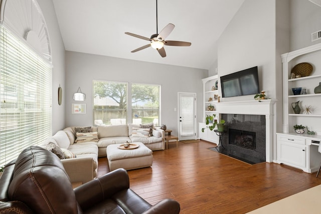 12002 Iris Canyon Dr, Tomball, TX 77377 - living room featuring a tiled fireplace, high vaulted ceiling, ceiling fan, and wood finished floors