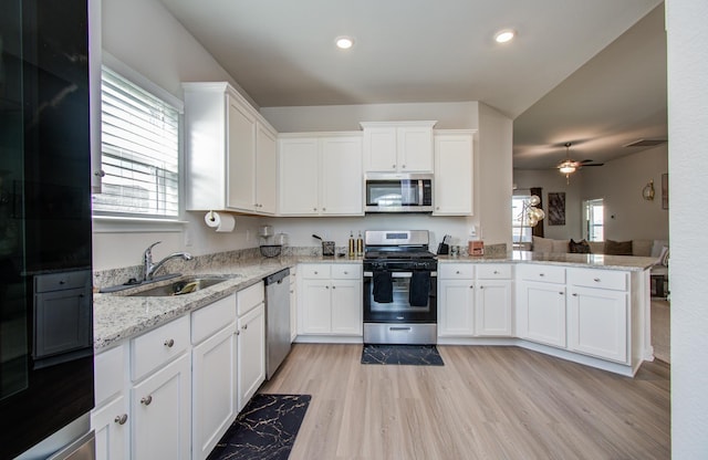 3121 Freeboard Dr, Texas City, TX 77510 - kitchen featuring appliances with stainless steel finishes, a sink, white cabinetry, a peninsula, and light wood-style floors