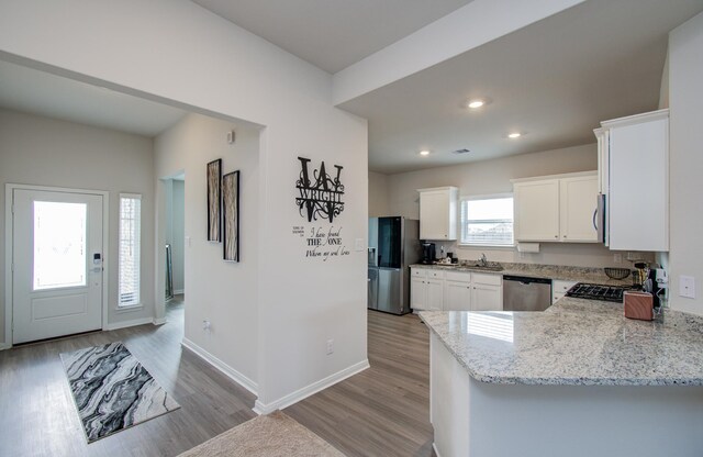 3121 Freeboard Dr, Texas City, TX 77510 - kitchen featuring stainless steel appliances, light stone countertops, light wood-style flooring, white cabinets, and a sink