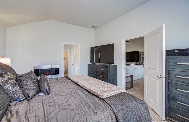 3121 Freeboard Dr, Texas City, TX 77510 - bedroom featuring light colored carpet, vaulted ceiling, a glass covered fireplace, and connected bathroom
