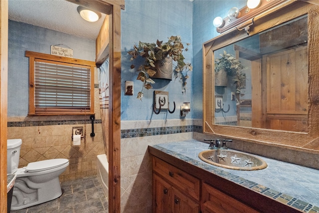 1816 County Road 936b, Alvin, TX 77511 - full bath with toilet, vanity, a bathtub, tile walls, and wainscoting