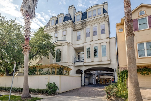 1652 Norfolk St Unit A, Houston, TX 77006 - view of front of home with decorative driveway, mansard roof, stucco siding, and a gate
