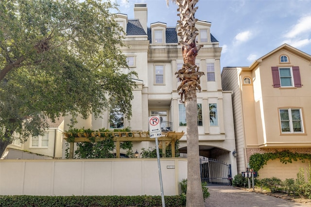 1652 Norfolk St Unit A, Houston, TX 77006 - view of front of property with mansard roof, a gate, and fence