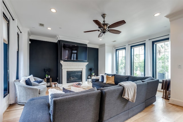 1652 Norfolk St Unit A, Houston, TX 77006 - living area with a glass covered fireplace, light wood-type flooring, a ceiling fan, crown molding, and baseboards