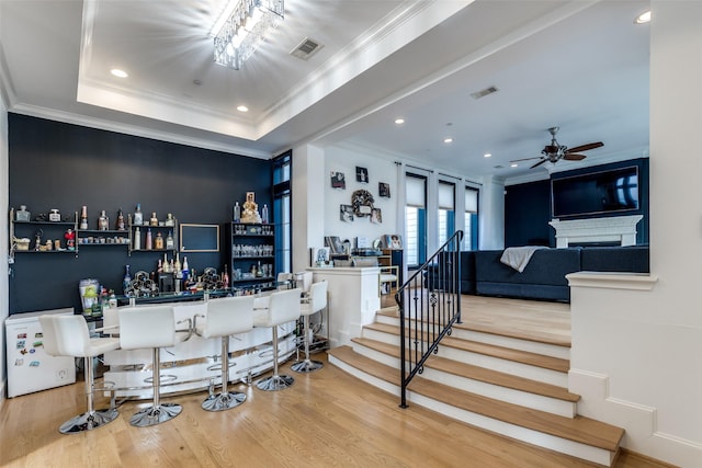 1652 Norfolk St Unit A, Houston, TX 77006 - indoor dry bar featuring wood finished floors, stairs, ceiling fan, a fireplace, and crown molding