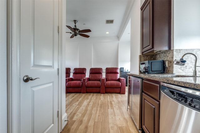 1652 Norfolk St Unit A, Houston, TX 77006 - kitchen with stainless steel dishwasher, a sink, black microwave, a ceiling fan, and backsplash