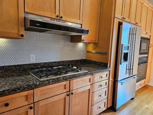 3818 Hazard St, Houston, TX 77098 - kitchen with black appliances, under cabinet range hood, light wood-style floors, backsplash, and dark stone countertops