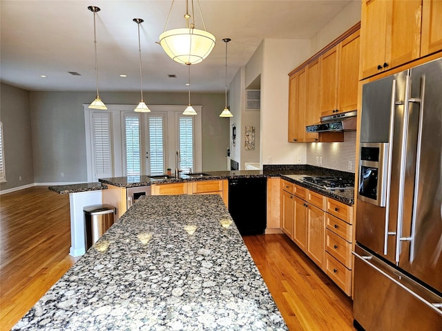 3818 Hazard St, Houston, TX 77098 - kitchen with high end refrigerator, black dishwasher, a peninsula, under cabinet range hood, and light wood-style floors