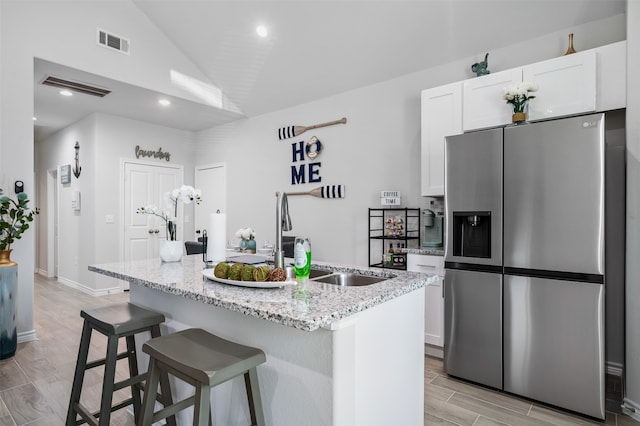 16858 W Alderson, Montgomery, TX 77316 - kitchen with stainless steel fridge with ice dispenser, a sink, white cabinetry, lofted ceiling, and wood finish floors