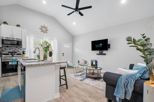 16858 W Alderson, Montgomery, TX 77316 - kitchen featuring appliances with stainless steel finishes, a ceiling fan, a breakfast bar area, a sink, and a kitchen island with sink