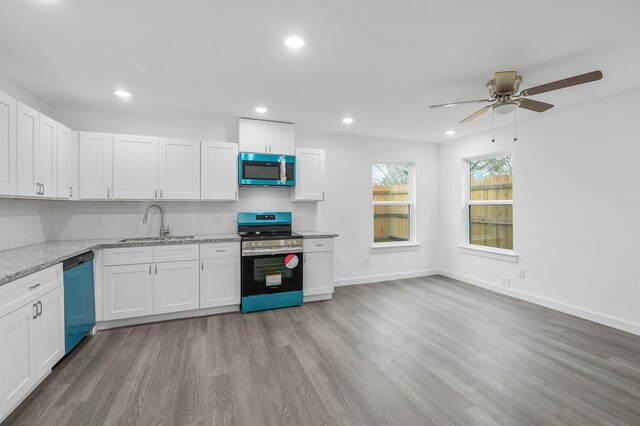 2322 Wavell St, Houston, TX 77088 - kitchen featuring stainless steel appliances, a sink, a ceiling fan, tasteful backsplash, and light wood-style flooring
