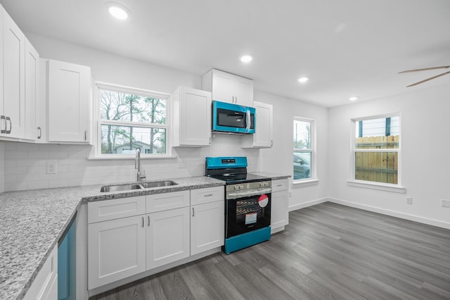 2322 Wavell St, Houston, TX 77088 - kitchen featuring stainless steel range with electric stovetop, a sink, white cabinetry, backsplash, and recessed lighting
