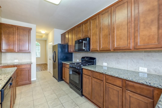 8919 Inglebrook Ln, Houston, TX 77083 - kitchen with black appliances, baseboards, tasteful backsplash, and light stone countertops