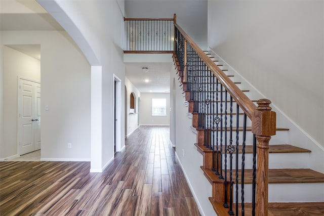 8919 Inglebrook Ln, Houston, TX 77083 - stairway with arched walkways, wood finished floors, baseboards, and a towering ceiling