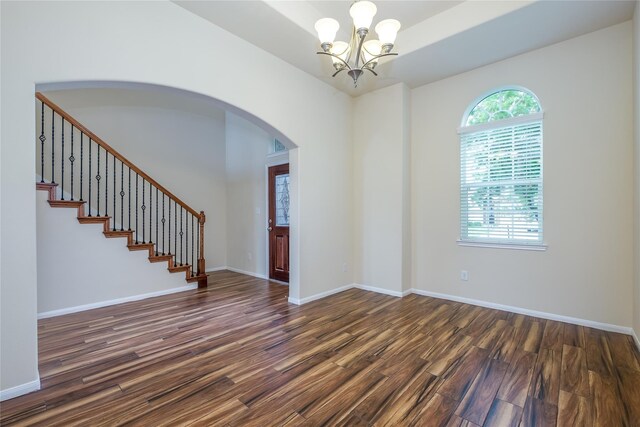 8919 Inglebrook Ln, Houston, TX 77083 - unfurnished room featuring dark wood-style flooring, arched walkways, a chandelier, stairs, and baseboards
