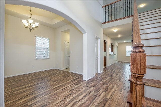 8919 Inglebrook Ln, Houston, TX 77083 - entryway featuring a chandelier, arched walkways, dark wood-style flooring, and healthy amount of natural light
