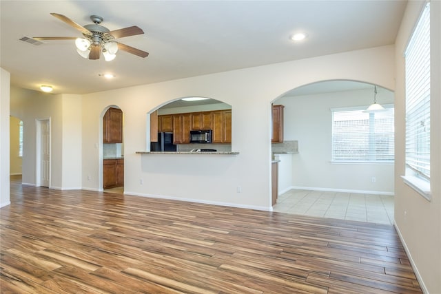 8919 Inglebrook Ln, Houston, TX 77083 - unfurnished living room with wood finished floors, a ceiling fan, plenty of natural light, recessed lighting, and baseboards