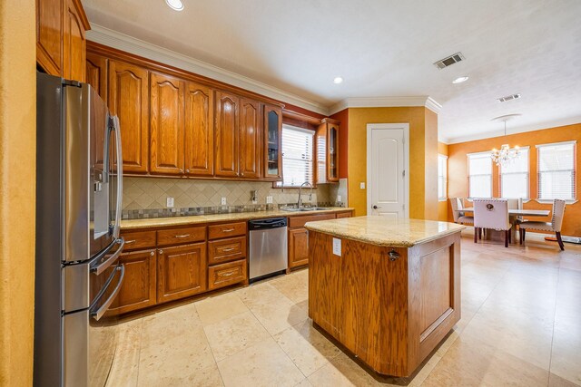 8606 Argentina St, Jersey Village, TX 77040 - kitchen featuring appliances with stainless steel finishes, a chandelier, brown cabinets, glass insert cabinets, and a sink