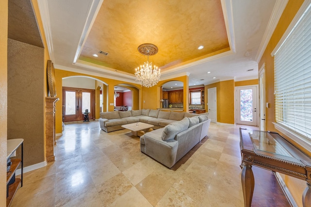 8606 Argentina St, Jersey Village, TX 77040 - living area featuring arched walkways, a tray ceiling, a chandelier, baseboards, and ornamental molding