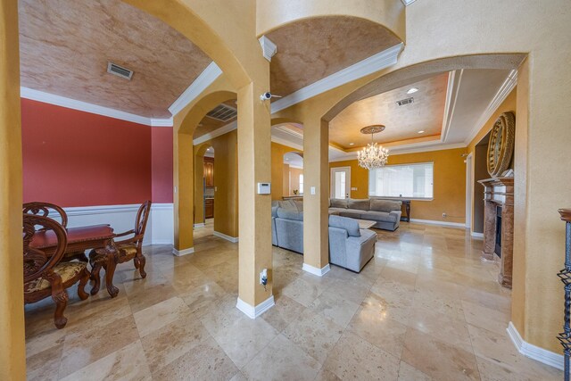 8606 Argentina St, Jersey Village, TX 77040 - living area featuring ornamental molding, arched walkways, a chandelier, baseboards, and a tray ceiling