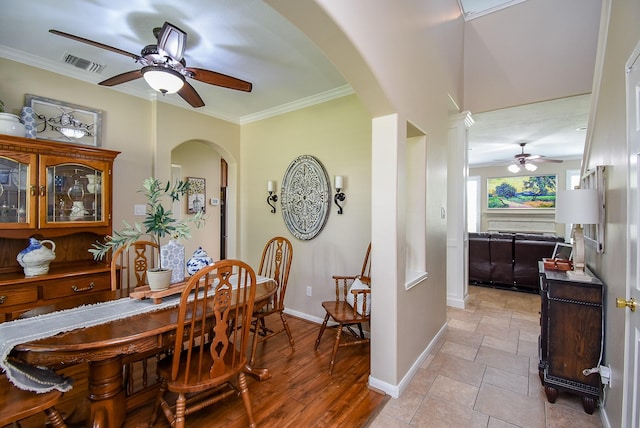 dining area with arched walkways, a ceiling fan, baseboards, and crown molding