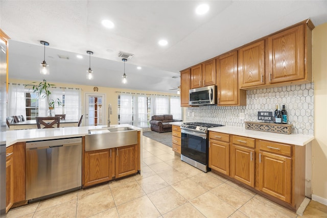 15703 W Astern Dr, Crosby, TX 77532 - kitchen featuring stainless steel appliances, a sink, tasteful backsplash, brown cabinets, and recessed lighting