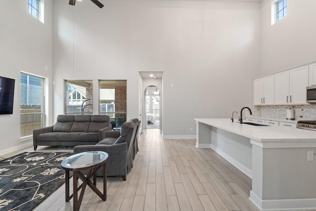 7010 Grassland Vista Ln, Katy, TX 77493 - living area with a towering ceiling, light wood-type flooring, and a ceiling fan