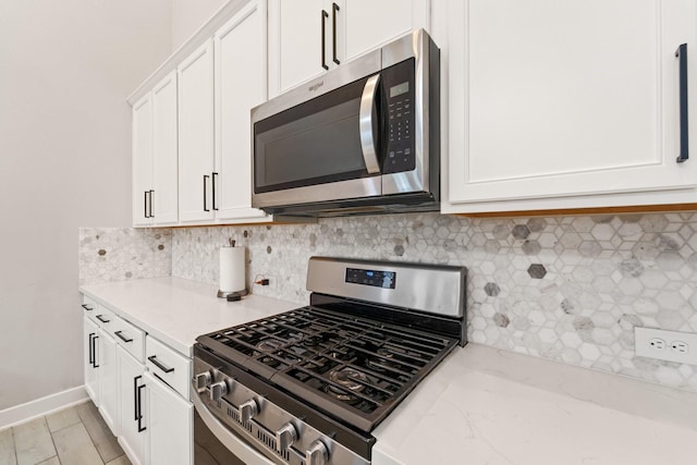 7010 Grassland Vista Ln, Katy, TX 77493 - kitchen featuring appliances with stainless steel finishes, white cabinets, backsplash, and light stone countertops