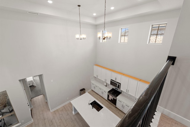 7010 Grassland Vista Ln, Katy, TX 77493 - stairs with a chandelier, a raised ceiling, recessed lighting, and wood finished floors